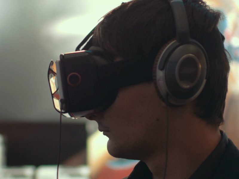 Close-up shot of a man in headphones getting experience in using VR-headset. Augmented reality device creating virtual space for smartphone applications